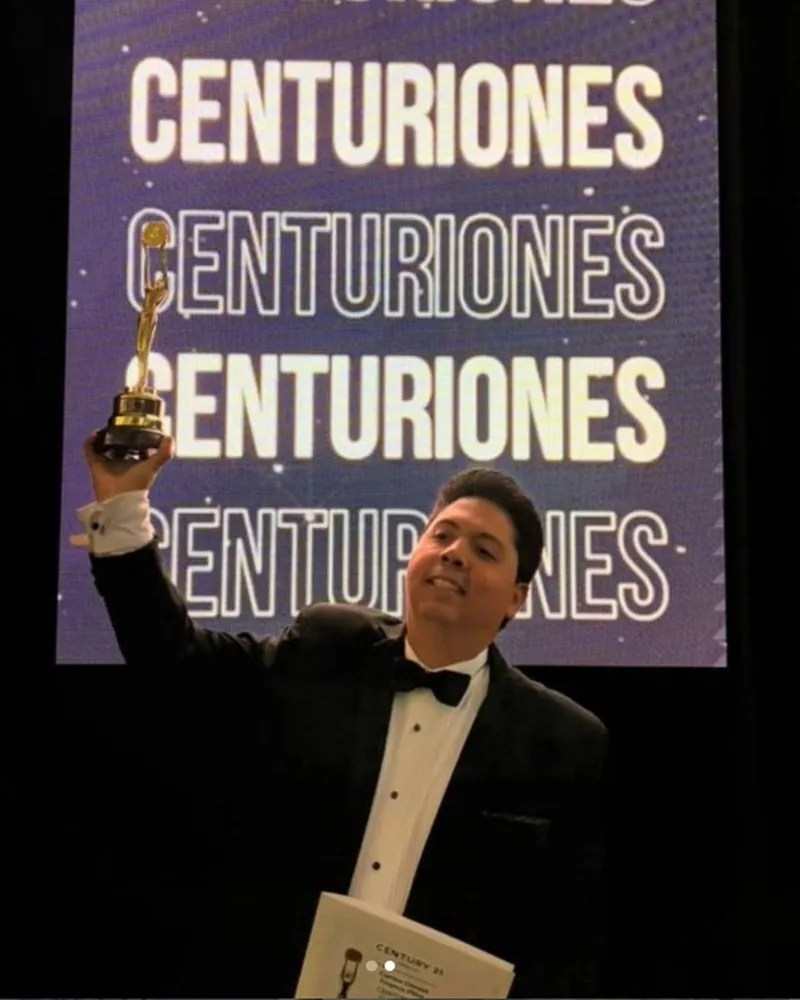Carlos Franco levanta el galardón Centurión durante la premiación de Century 21