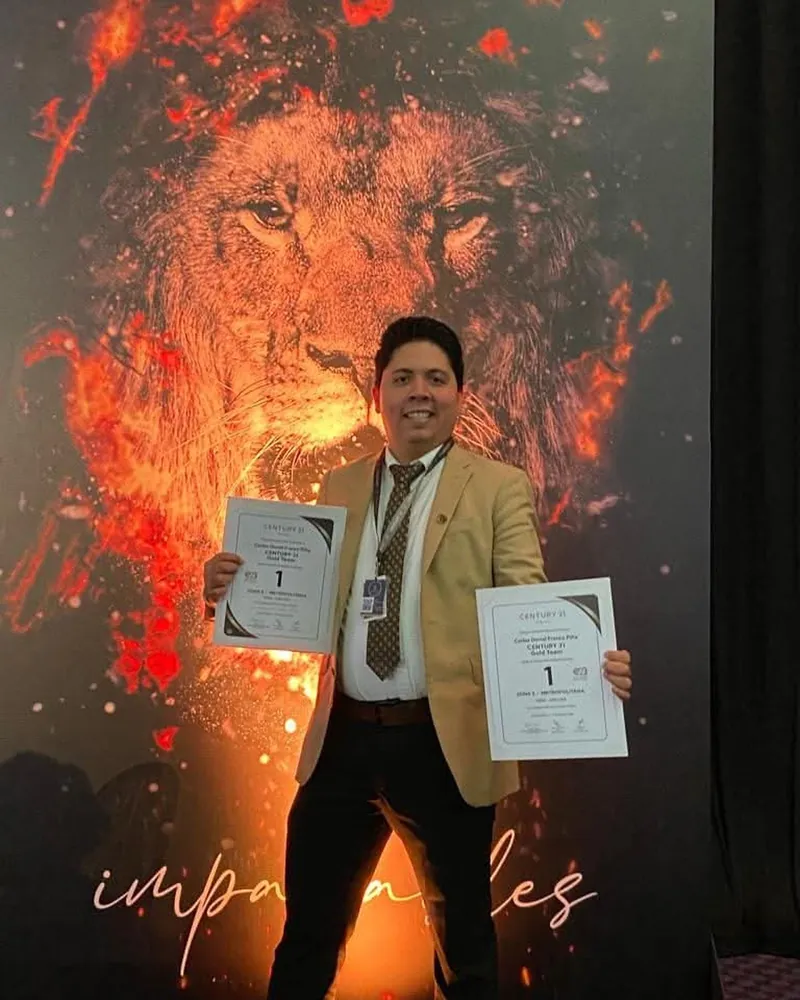 Carlos Franco sostiene dos certificados de primer lugar de la Zona 5